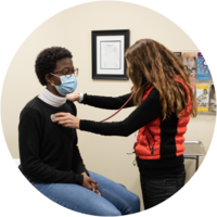 A nurse practitioner checks a patients heartbeat.